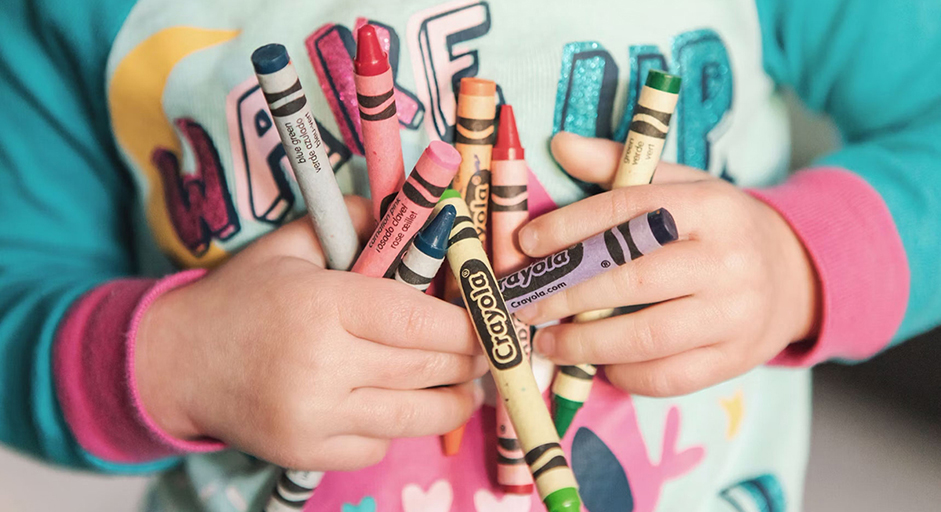 Image of child holding crayons